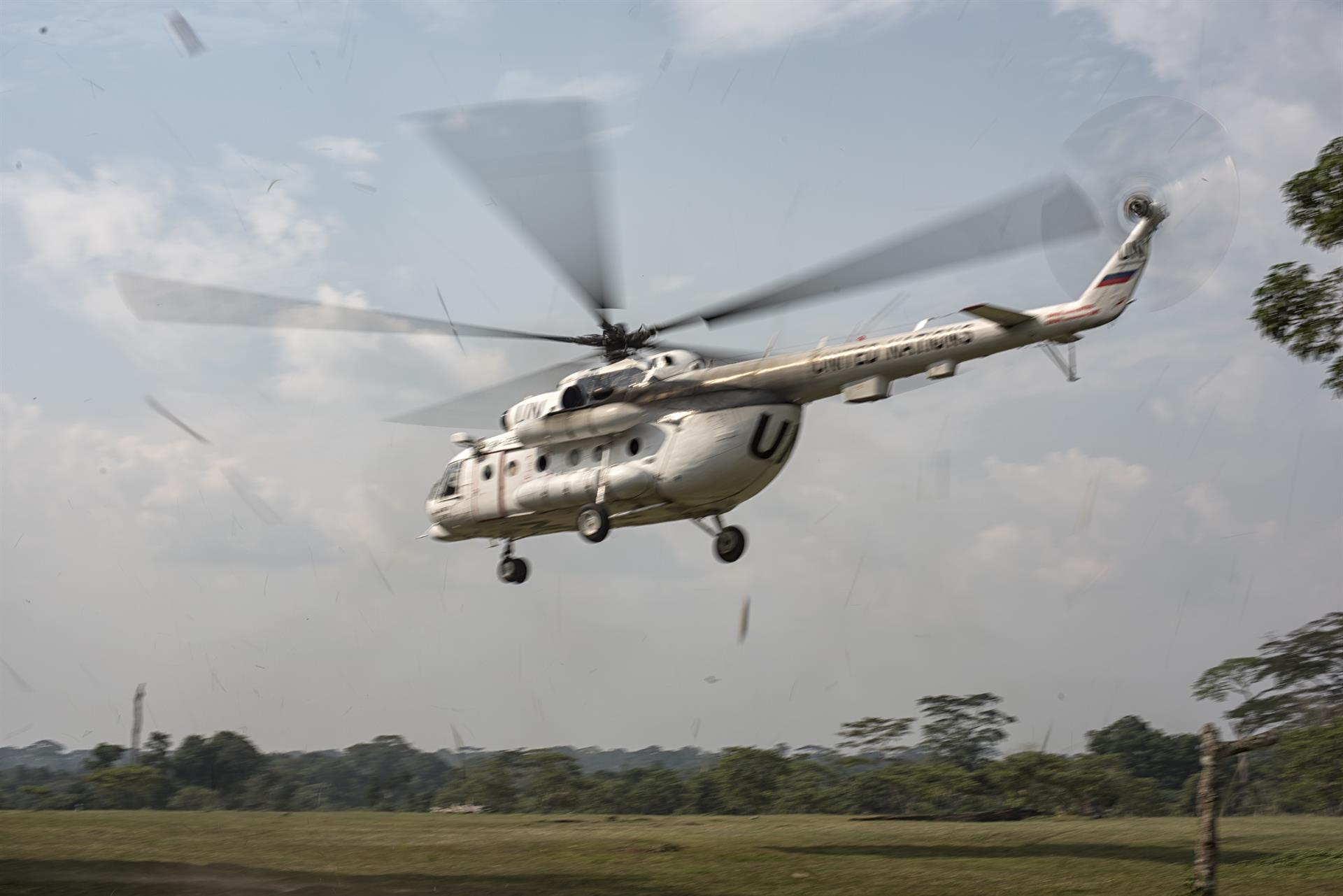 A United Nations helicopter lands in a field in Itipo, a remote village affected by the Ebola outbreak. The field had to be cleared by hand so that the helicopter could land and the response team could set up a base camp in the area.