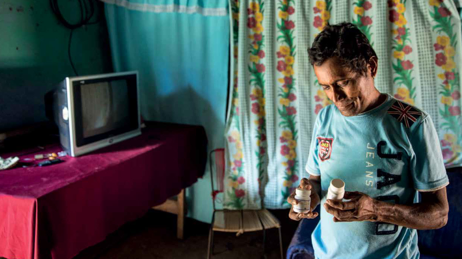 Man holding a box of antiretroviral treatment pills
