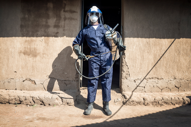 Sprayer about to enter a house in western Kenya where the walls will be sprayed with insecticides to kill malaria-carrying mosquitoes.