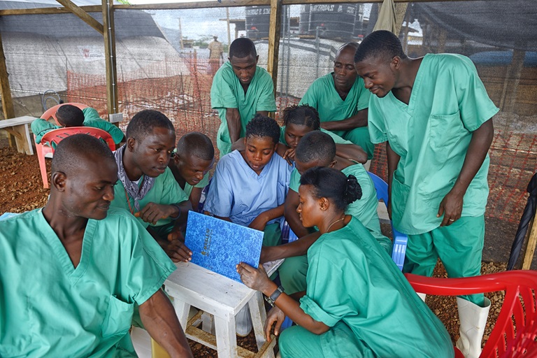 africa ebola health workers Health workers in Africa huddled around a laptop, as part of their work around Ebola