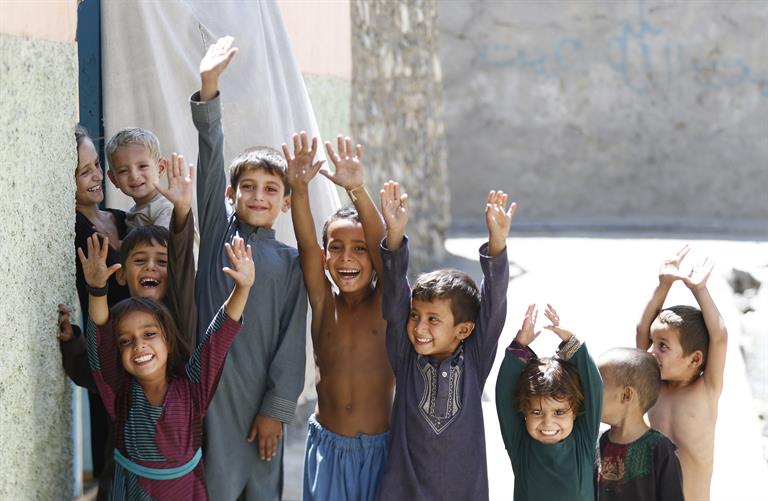 Young boys and girls raise their hands to show marks of vaccination against polio, in Afghanistan
