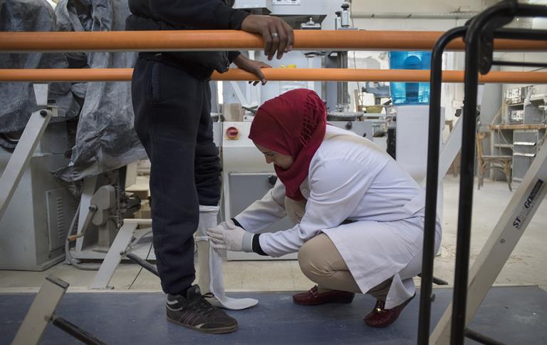 A technician fits Ismail, 17, from Qamishli, for a prosthetic foot
