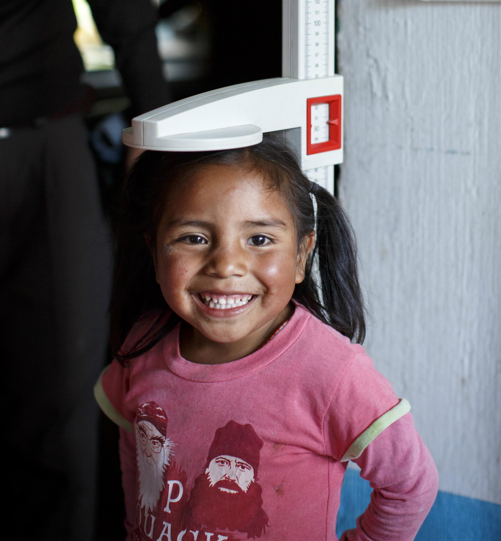 Woman measures baby's head for microcephaly.
