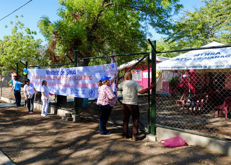 A group of health workers putting up a banner, in Nicaragua