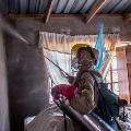 A worker is spraying the inside walls of homes with long-lasting insecticides.