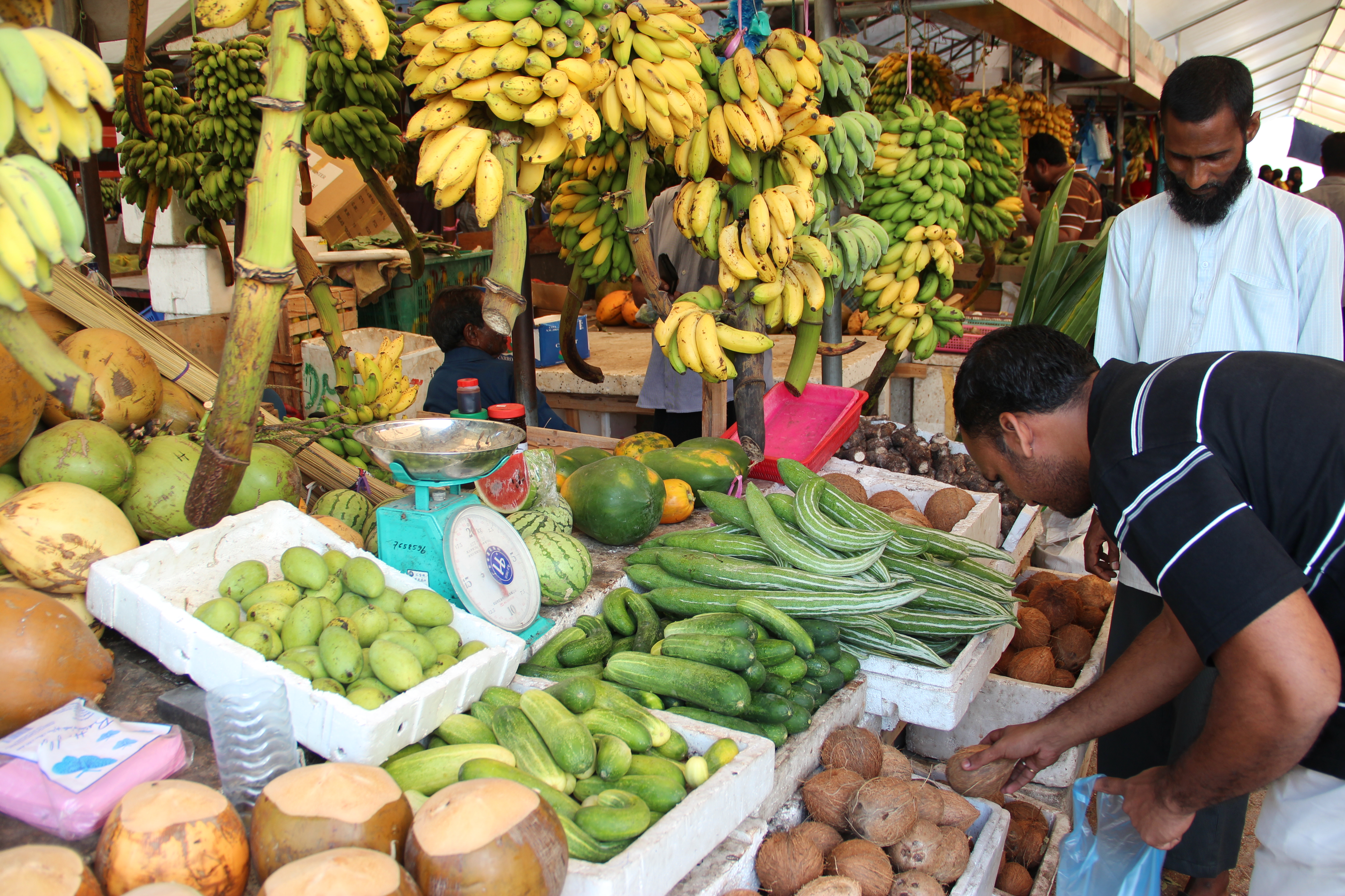A man selecting vegetables at a market in Maldives