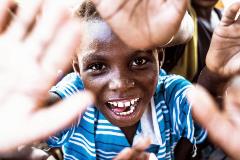 Jeune garçon afrcain lève les paumes de mains