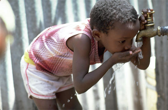 child  at a water supply, Jamaica