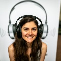 A young woman smiling with headphones on