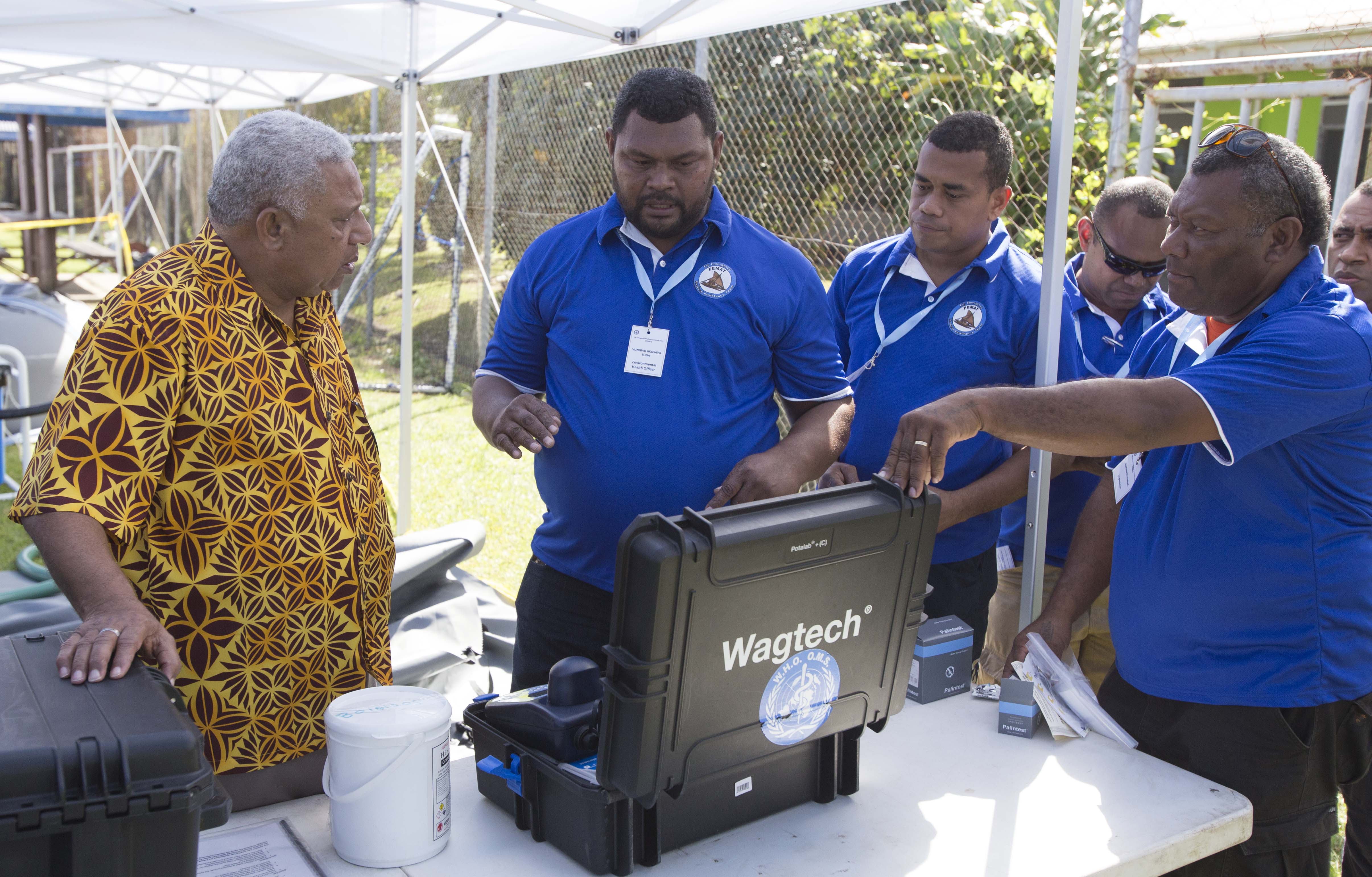 Fijian Prime Minister Josaia Voreqe Bainaimarama alongside FEMAT staff conducting water testing